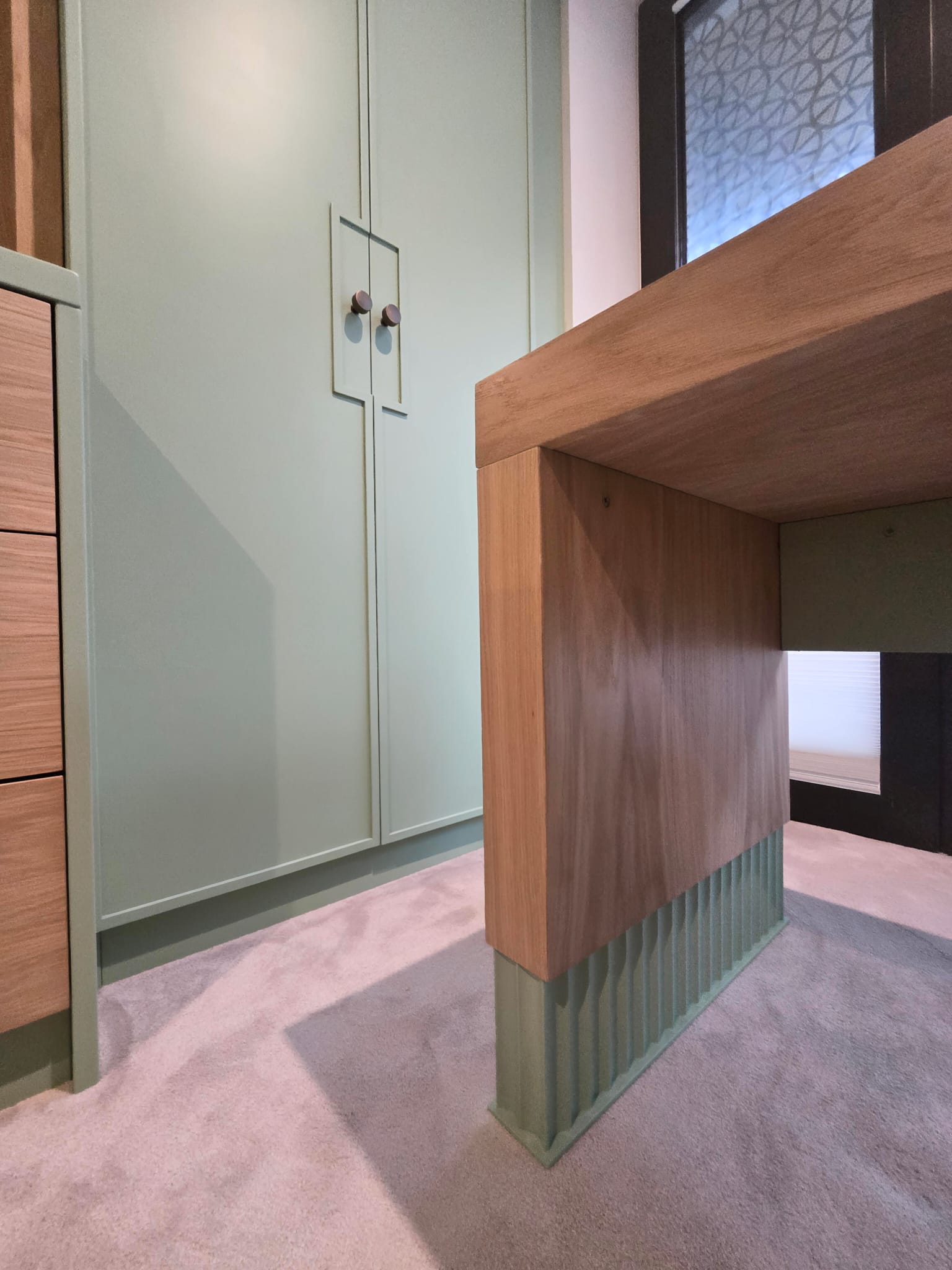 Natural oak-veneered desk extension beside fitted bedroom wardrobes in Greenwich