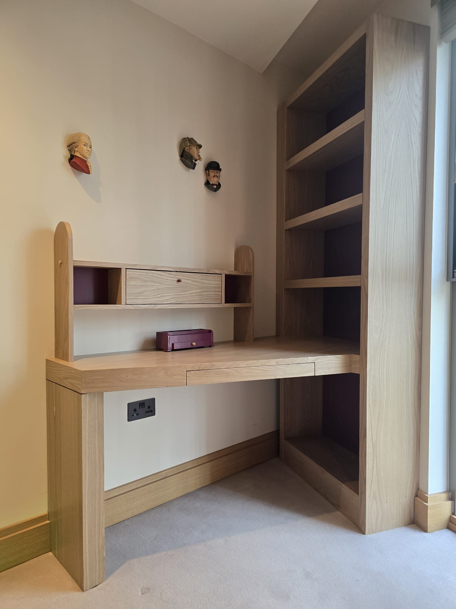 Oak-veneered corner desk and tall fitted bookcase in a children's bedroom in Westminster, London