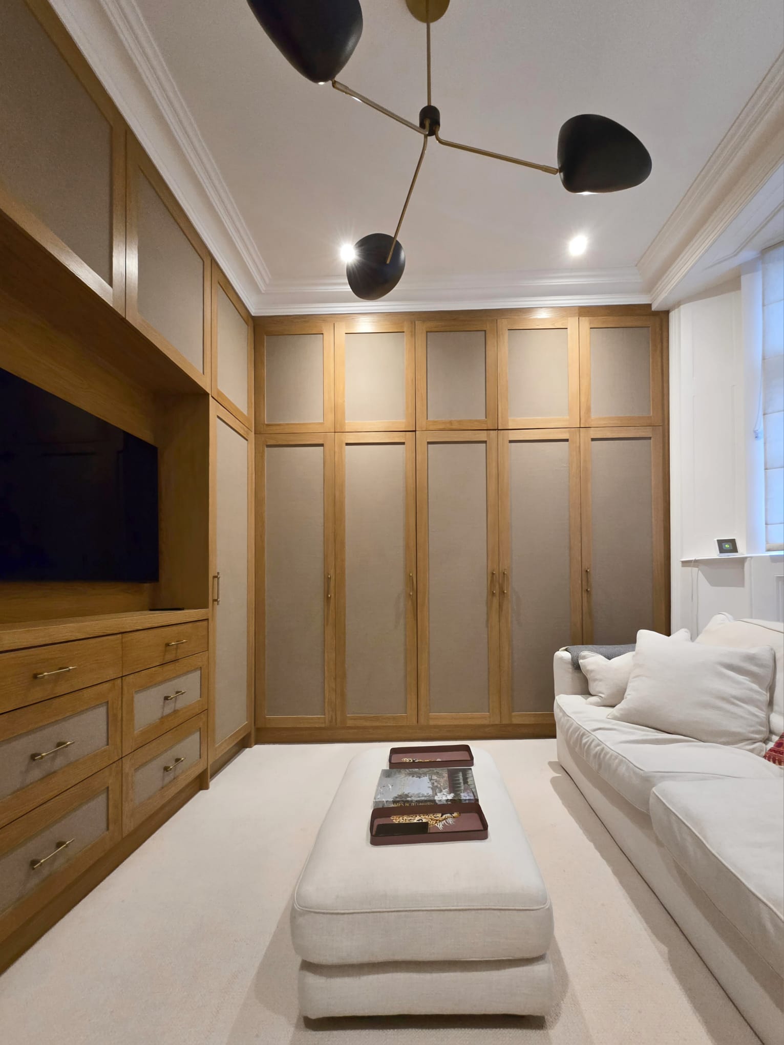 Floor-to-ceiling oak-framed fabric wardrobes in a Holland Park dressing room