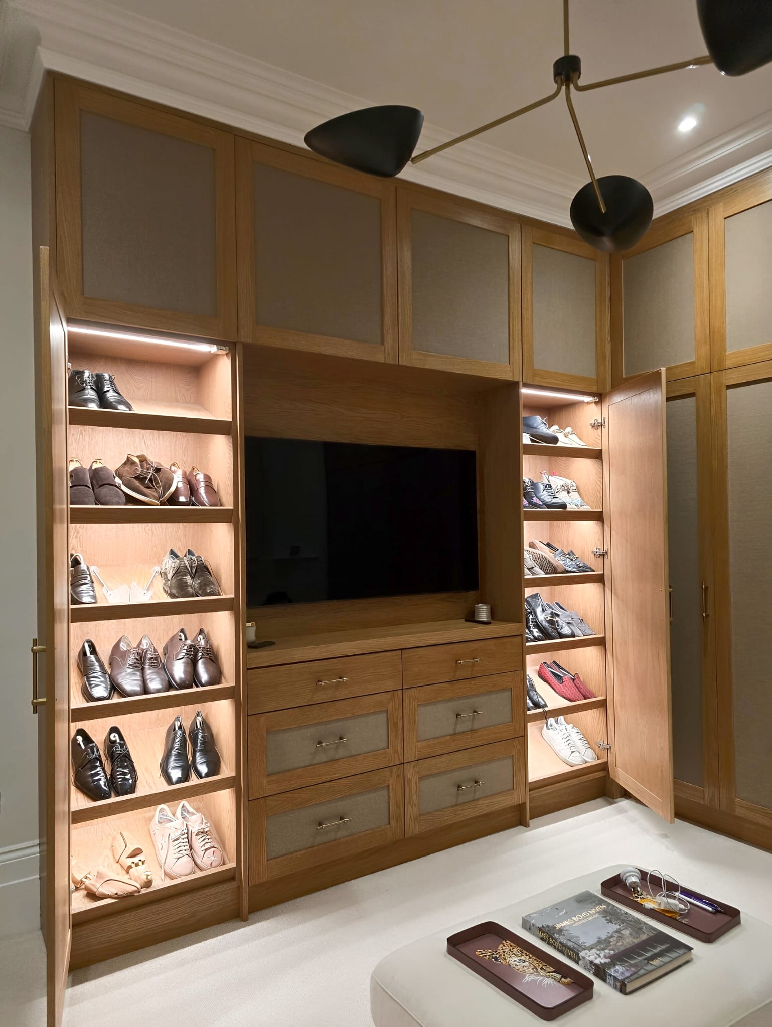 Illuminated shoe storage beside oak-framed fabric wardrobes in Holland Park