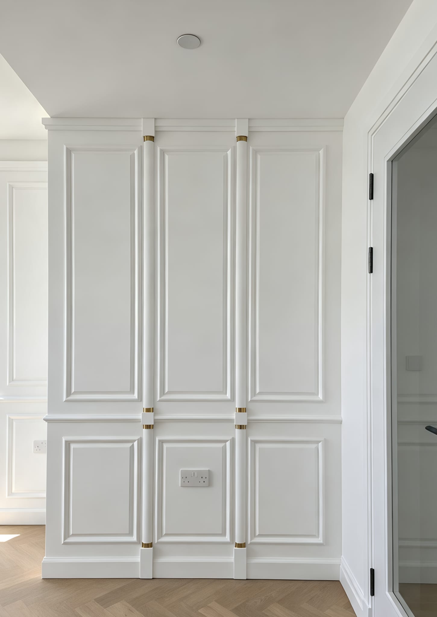 Tall framed wall panels with small brass details in the Chelsea installation
