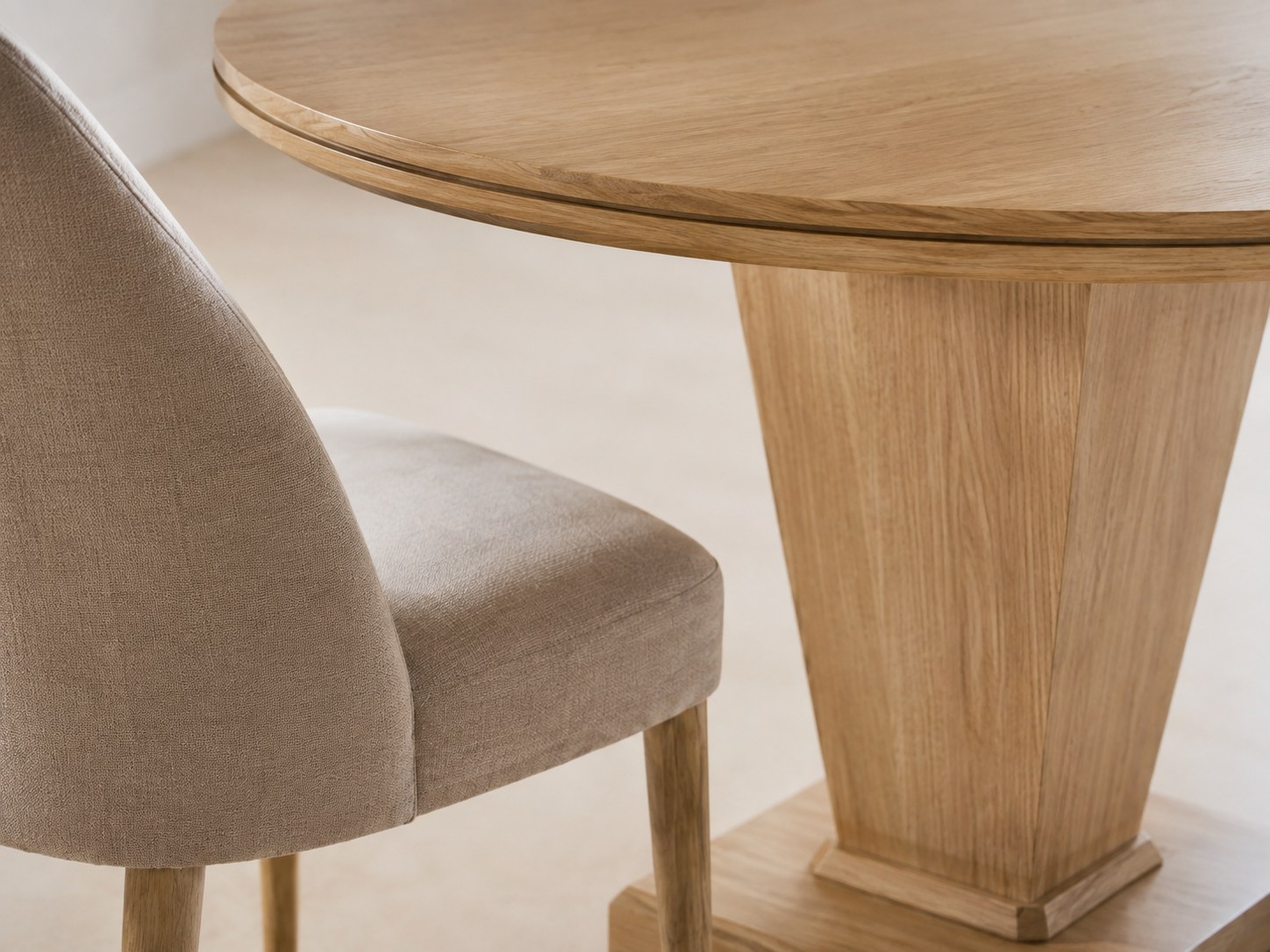 Close view of the tapered oak pedestal and fine gilt line beneath the tabletop
