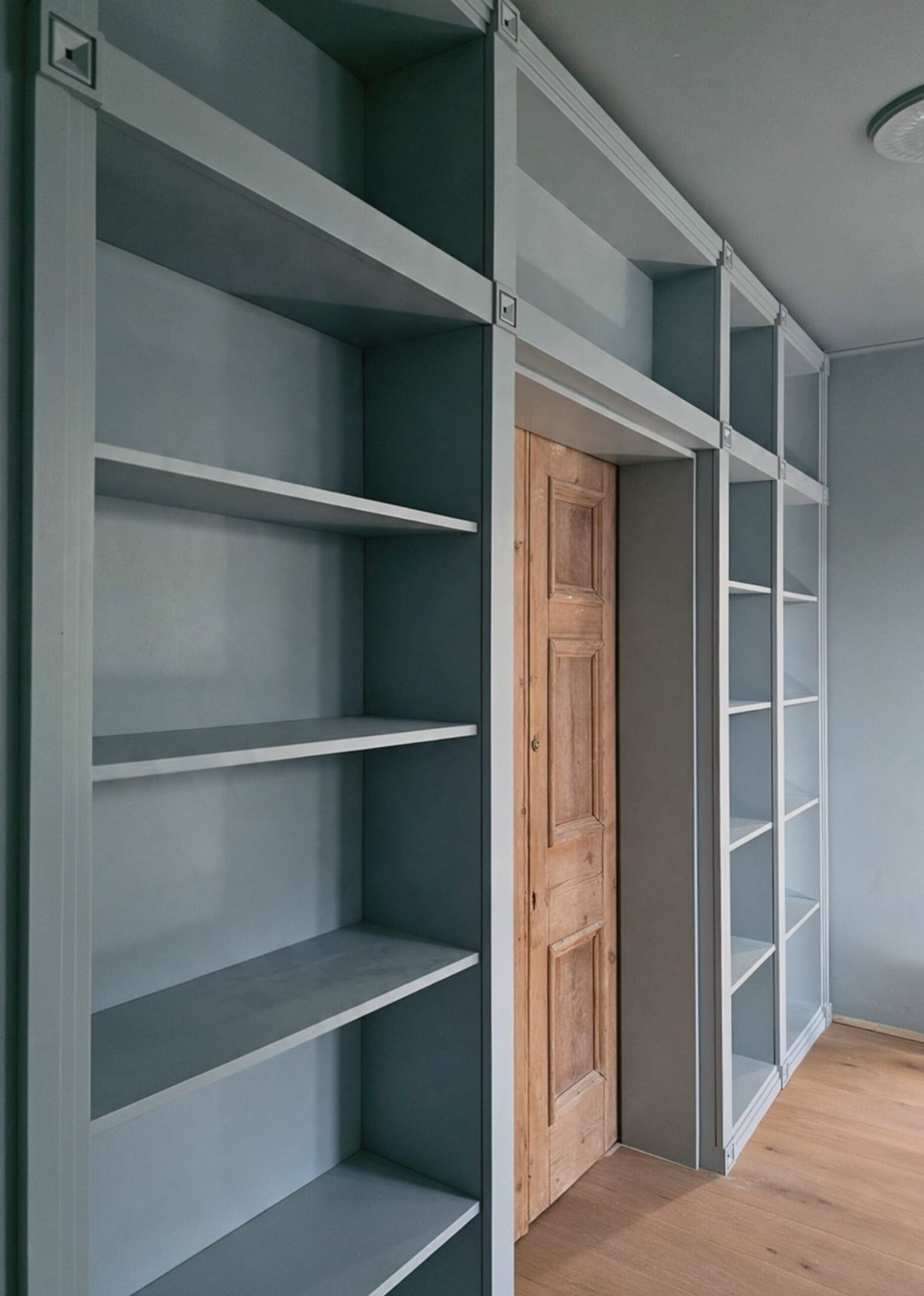 Angled view of full-height open shelving and decorative bookcase uprights in Shoreditch