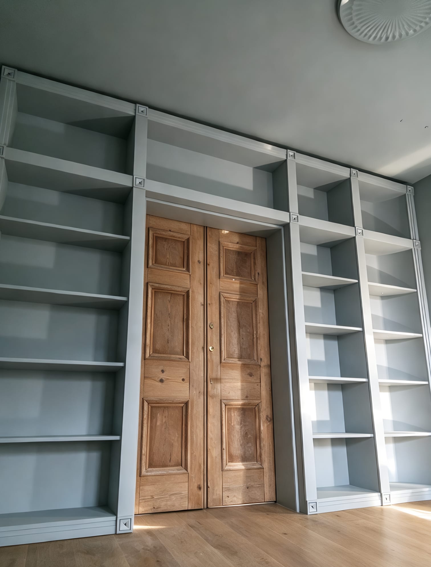 Painted fitted bookcase with open shelves around a timber doorway in Shoreditch