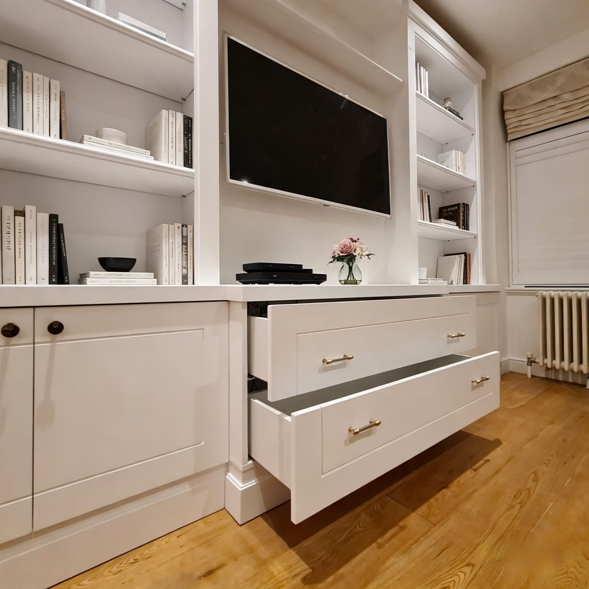 Open deep drawers integrated into a bespoke Lancaster Gate media wall