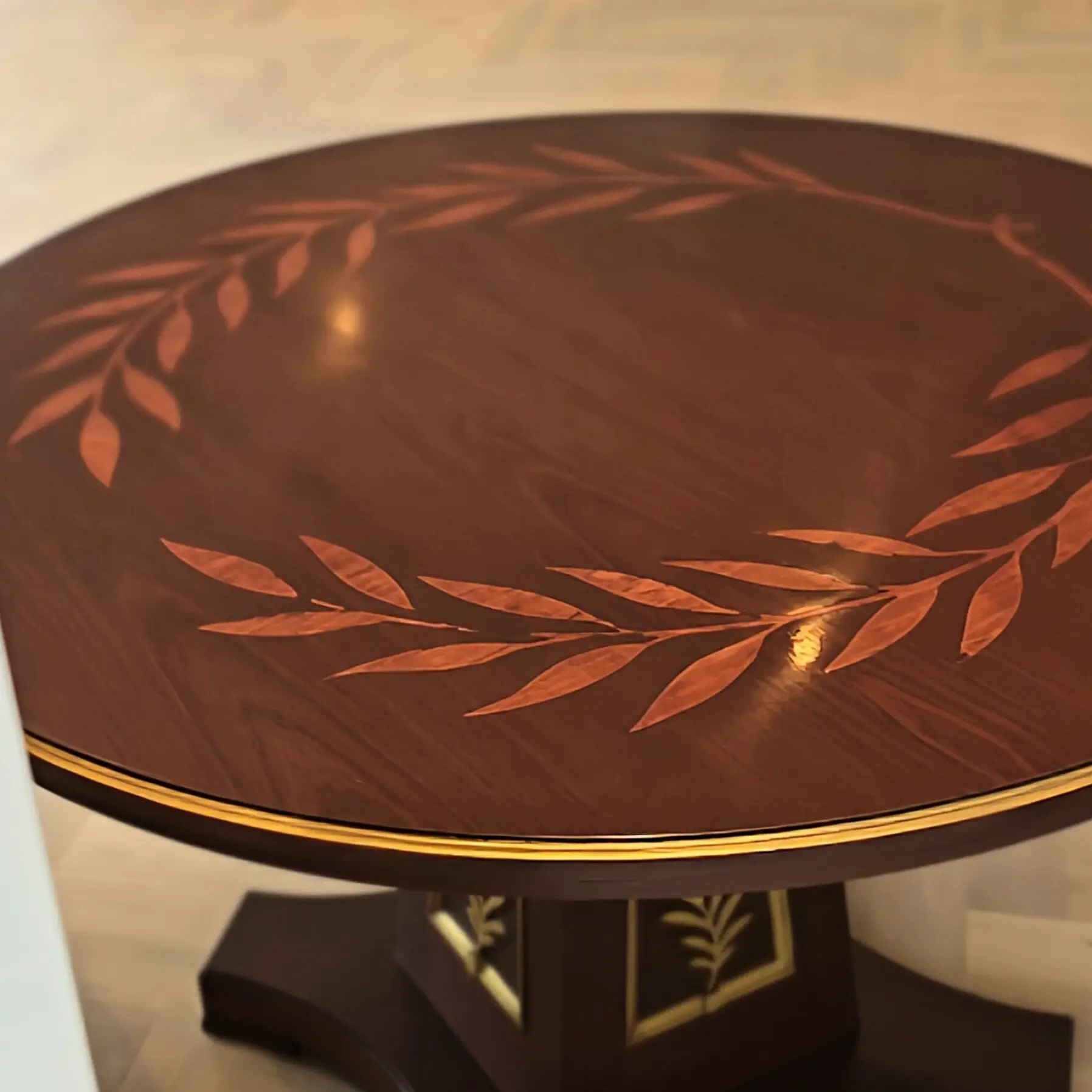 Bespoke marquetry dining table with laurel wreath inlay