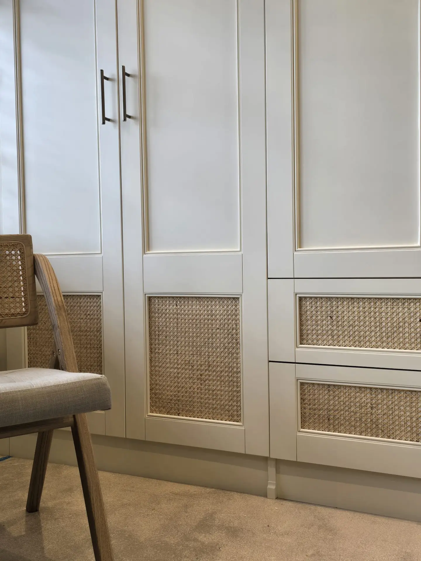 Brass handles and woven cane drawer fronts on bespoke fitted wardrobes in Harrow