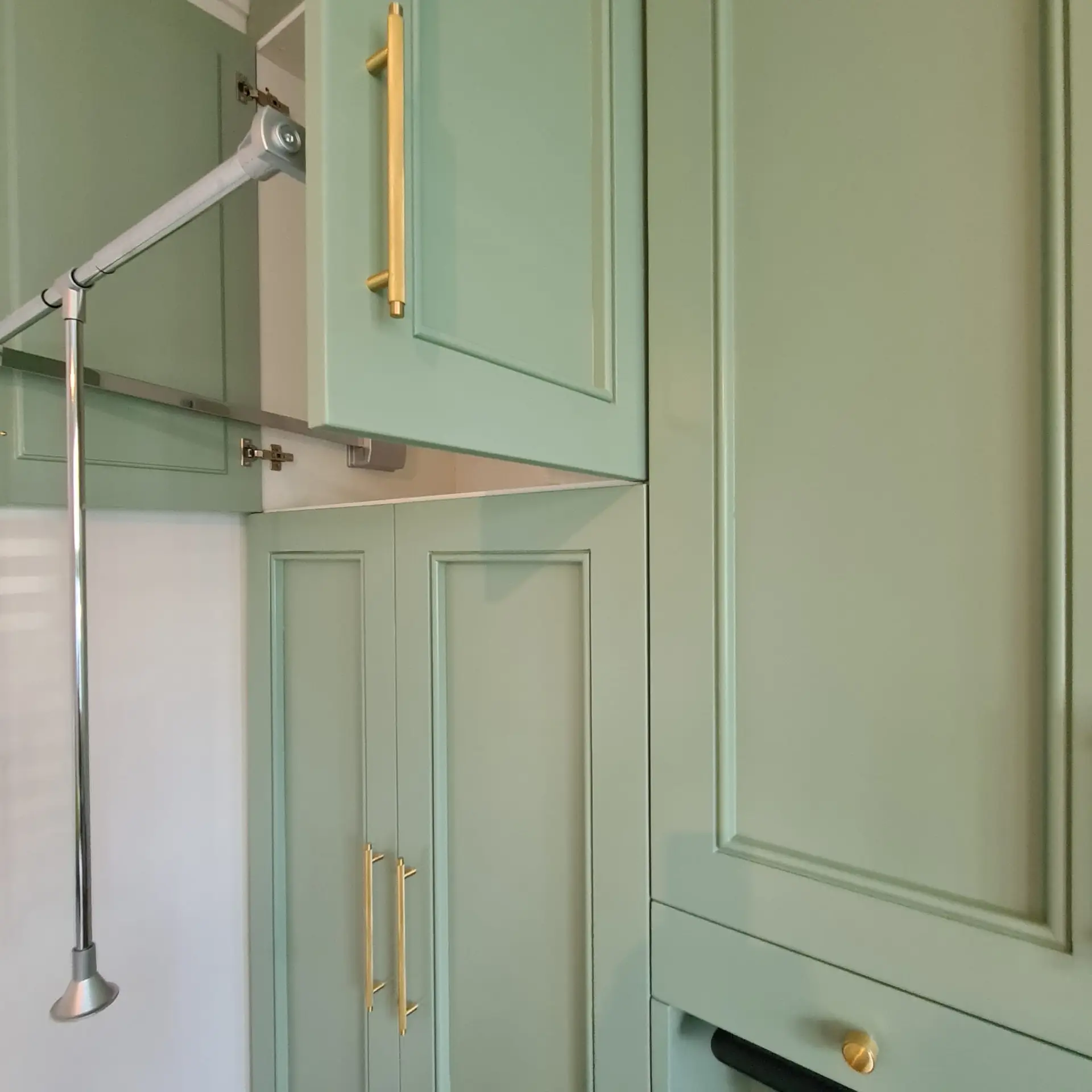 Sage green bespoke fitted wardrobes with brass detailing in Bromley