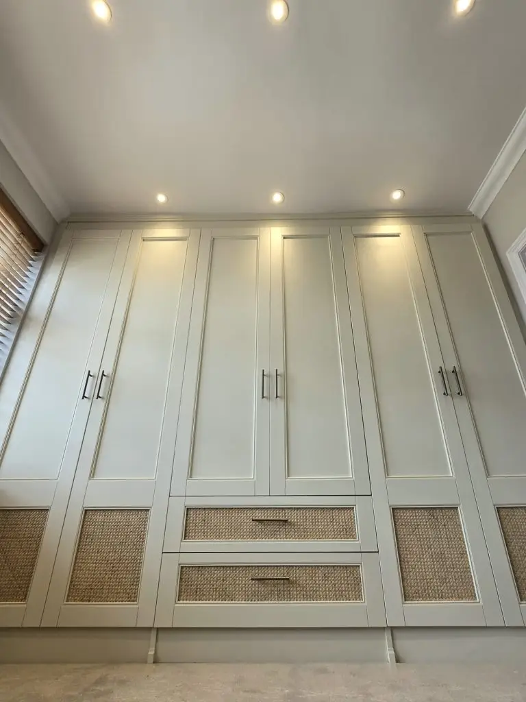 Cane panel wardrobe and integrated drawer craftsmanship in a Harrow bedroom