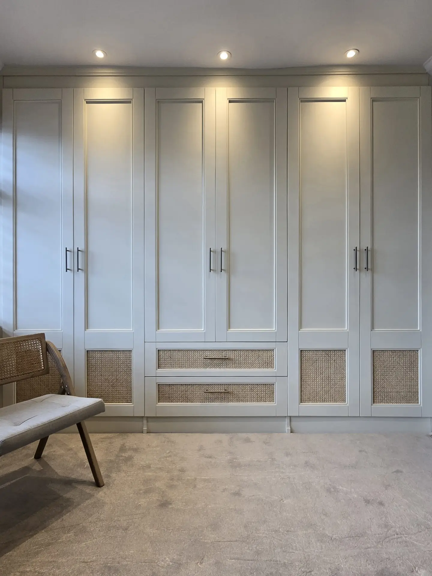 Floor-to-ceiling rattan detail fitted wardrobes in a Harrow bedroom