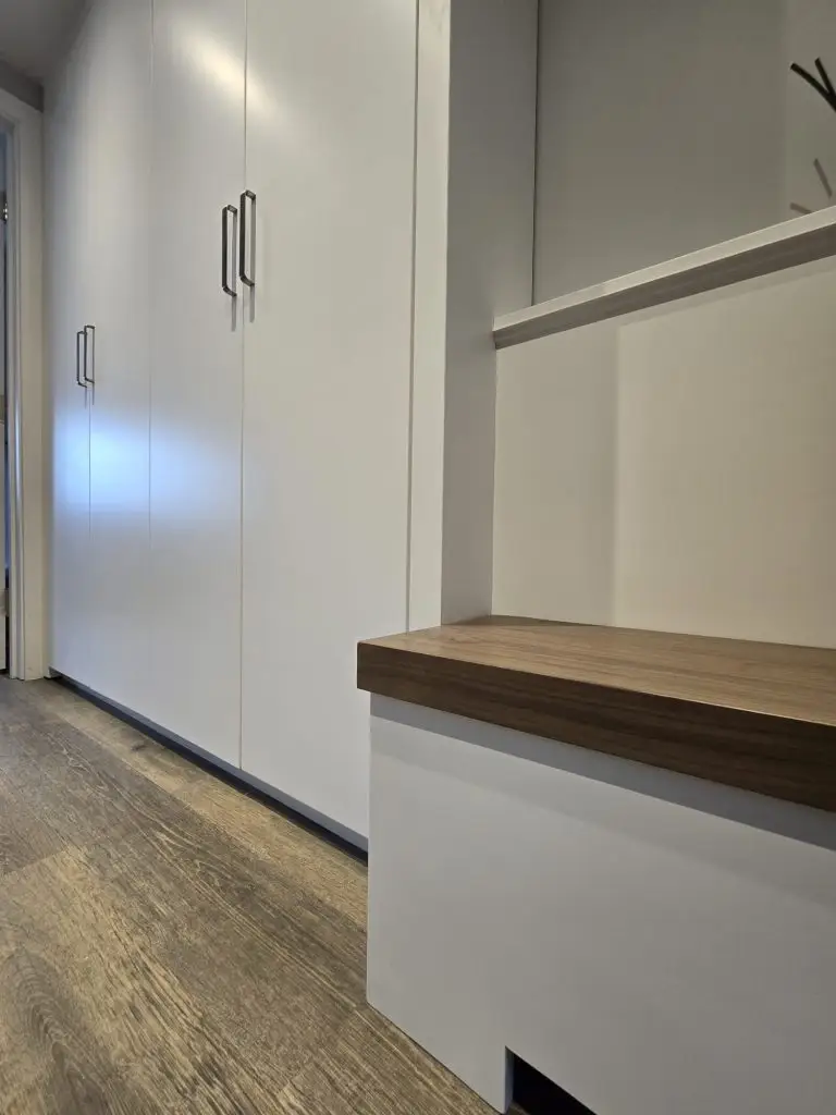 Floating walnut hallway bench beside fitted shoe storage in Stanmore, London