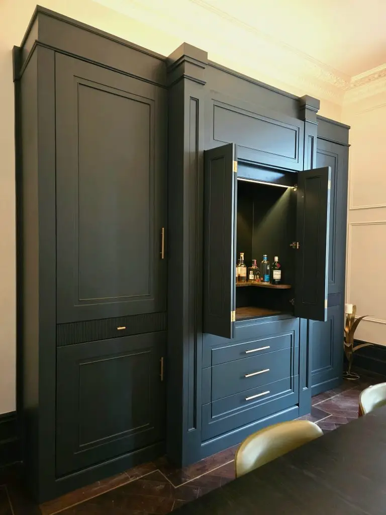Deep blue bespoke cabinetry meeting the original cornice in a Holland Park interior