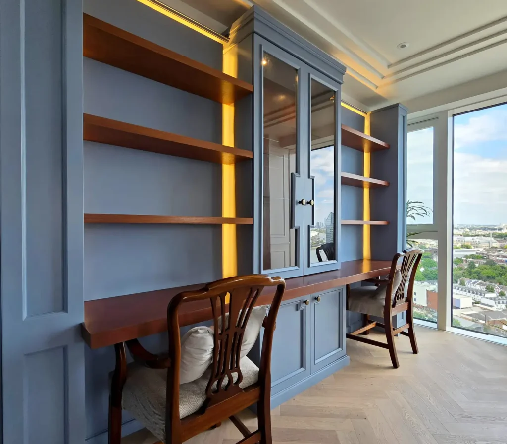 Dusty blue bespoke fitted library and integrated home office joinery in Chelsea Creek, London
