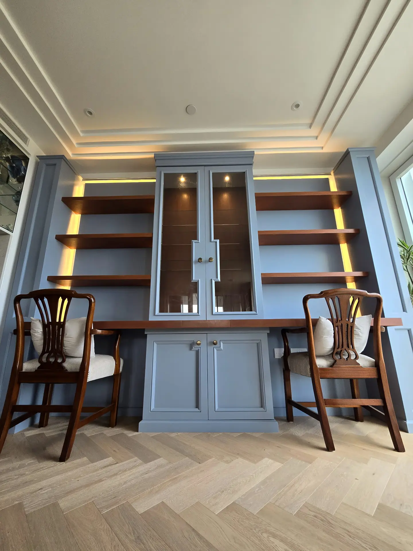 Full-height dusty blue fitted library wall with integrated workspace in Chelsea Creek