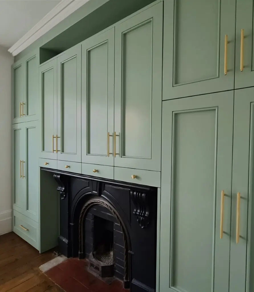 Sage green fitted wardrobe and bedroom storage with integrated desk
