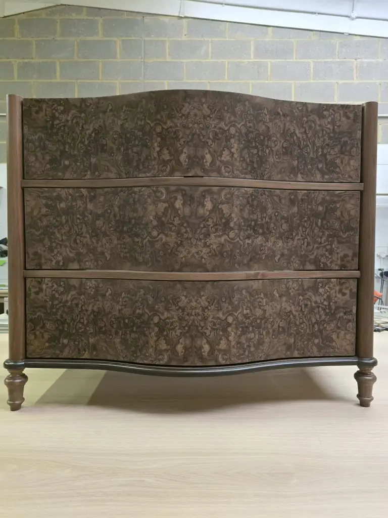 Bookmatched walnut burr veneer detail on a fitted vanity unit