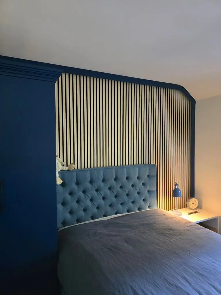 Fitted slatted headboard panel with bedside lighting in navy attic bedroom, Stansted Mountfitchet, Essex