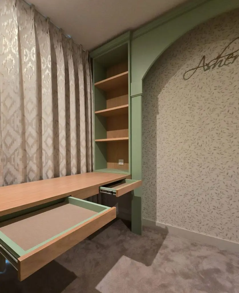 Bespoke sage green nursery — desk with twin pull-out drawers and integrated shelving