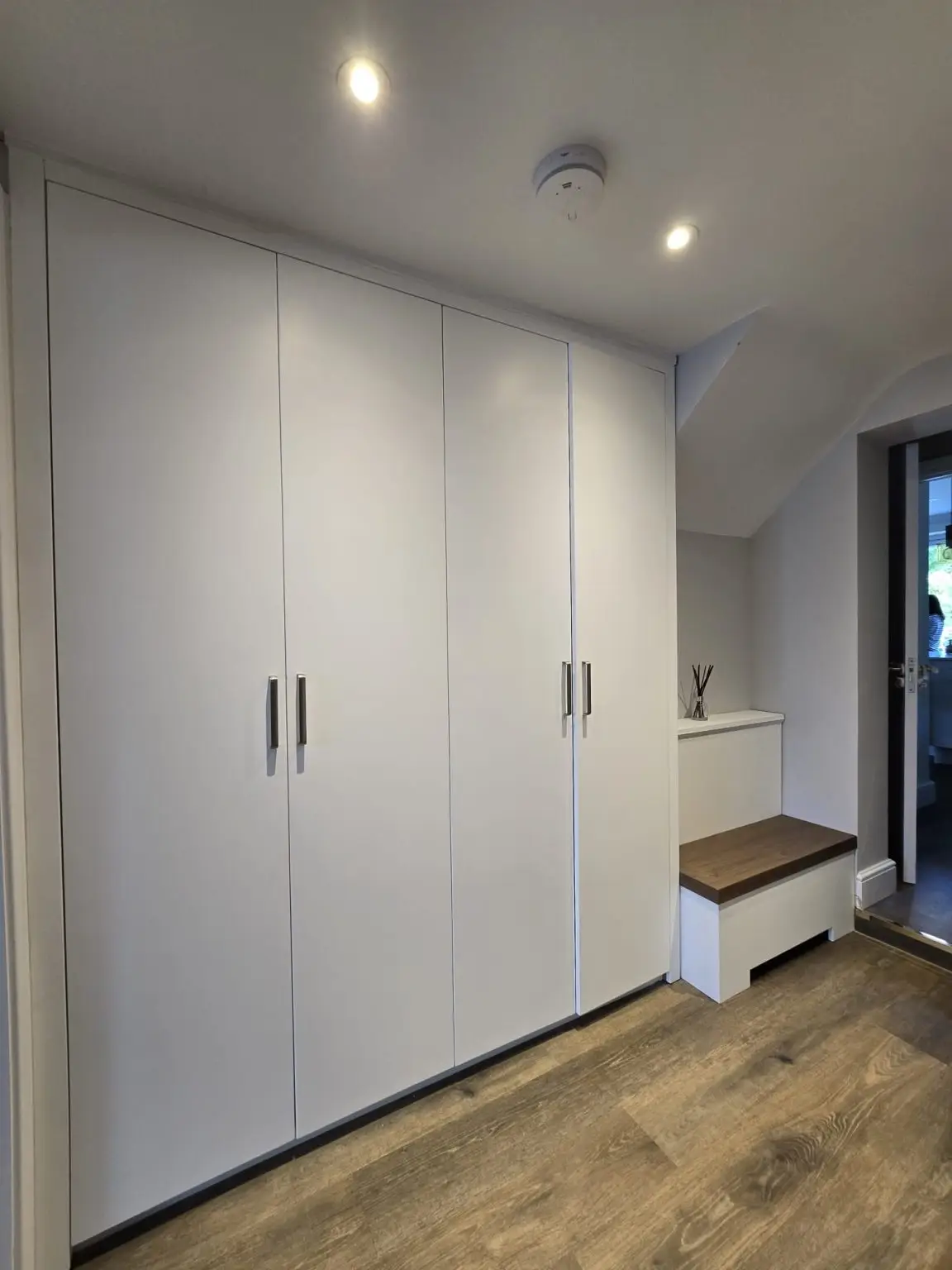 Floor-to-ceiling fitted shoe cabinets with a walnut hallway bench in Stanmore, London